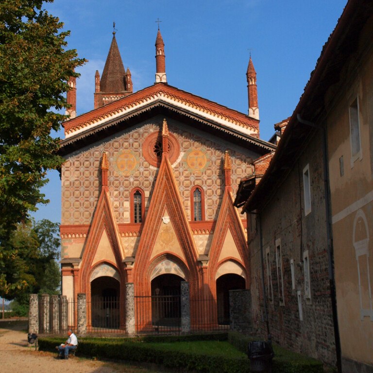 Facciata gotica dai grandi archi a punta in mattoni, arricchita da elaborate decorazioni geometriche e alti pinnacoli svettanti.